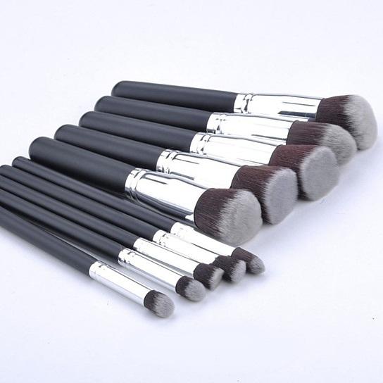 10-piece black makeup brush set arranged diagonally on a white background.